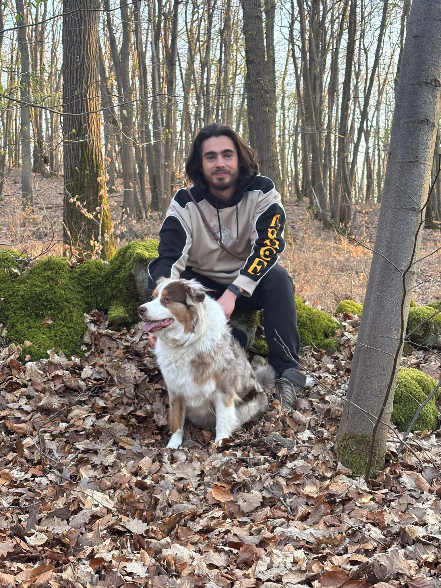 Éducateur canin Canixcellence assis avec son berger australien en forêt à Puiseux-en-France